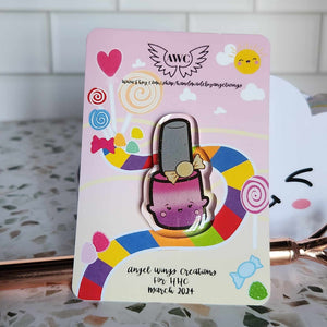 Angel Wings Creations has created a pin inspired by the Candy Castle in the Candyland board game.

The nail polish bottle is in a kawaii style with a new personality and in sweet pink color, with fine holo glitter. It measures 1.5" and there will be other styles to collect in the following months.

15 Cap