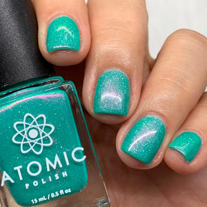 Atomic Polish continues their 'Board Game' theme with a polish inspired by the game, Azul!  "Azul" is a teal-based polish with aurora pigment that shifts gold to orange to pink and holographic flakes.  15ml Bottle