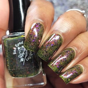 Red Eyed Lacquer continues their 'Iconic Movie Lines' with a polish inspired by Young Frankenstein!

"No, It's Pronounced FRONKENSTEEN!" has a grungy green jelly base with pink/purple shifting flakes and black flakes.