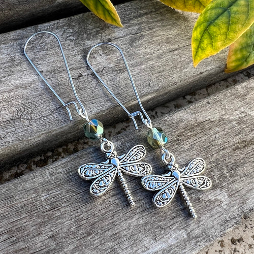 These elegant and whimsical earrings showcase a beautifully detailed, double-sided antique silver dragonfly—a symbol of hope, transformation, and resilience. A Czech glass fire polished round complements the design with a blue-green and pale olive luster finish. Stainless steel kidney shaped ear wires complete the look and also provide a comfortable fit for these lightweight dangles. 