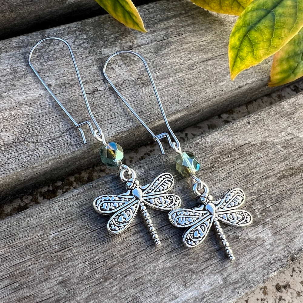 These elegant and whimsical earrings showcase a beautifully detailed, double-sided antique silver dragonfly—a symbol of hope, transformation, and resilience. A Czech glass fire polished round complements the design with a blue-green and pale olive luster finish. Stainless steel kidney shaped ear wires complete the look and also provide a comfortable fit for these lightweight dangles. 