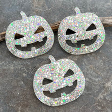 Bring some spooky sparkle to your space with this extra-large handcrafted pumpkin magnet that glows in the dark when exposed to UV light. It features a custom blend of gorgeous glow-in-the-dark, silver, and color-shifting opalescent glitters encased in resin, with a sturdy ceramic magnet on the back. Measuring just over 2.8" in diameter, this festive pumpkin is the perfect way to dress up your Helmer, fridge, file cabinet, or any metal surface for Halloween and beyond!