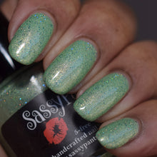 A moss green holographic base with green gold microshreds and emerald holographic pigment, this shade reflects forest floors kissed by sunlight and ancient strength rising from the earth. Earthy yet luminous, Rooted Radiance captures Gaia’s quiet resilience and enduring beauty.

15ml Bottle