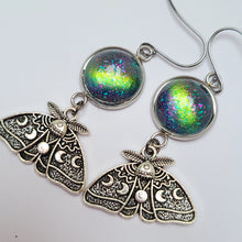 Baroness X continues their 'Magical &amp; Witchy Things' series with a pair of earrings inspired by the Lunar Moth!  These earrings are made of moon moth charms and handpainted glass cabs. The earring hooks are hypoallergenic and you will receive silicone earring backs as well.  They hang 2" from your ear piercing.
