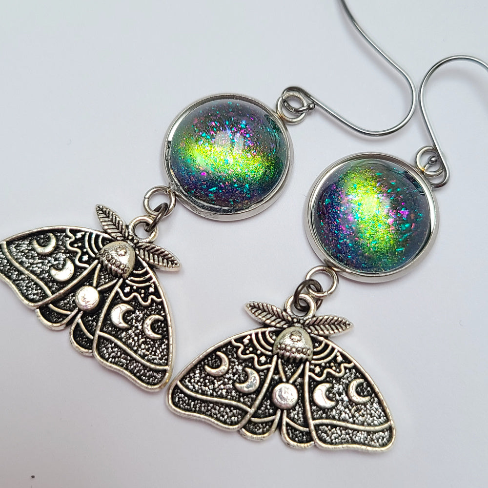 Baroness X continues their 'Magical & Witchy Things' series with a pair of earrings inspired by the Lunar Moth!  These earrings are made of moon moth charms and handpainted glass cabs. The earring hooks are hypoallergenic and you will receive silicone earring backs as well.  They hang 2